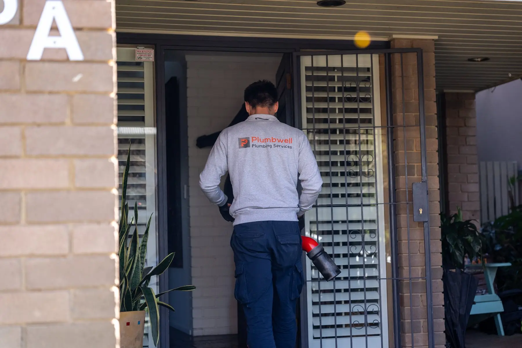 A Plumbwell emergency plumber at a Sydney front door