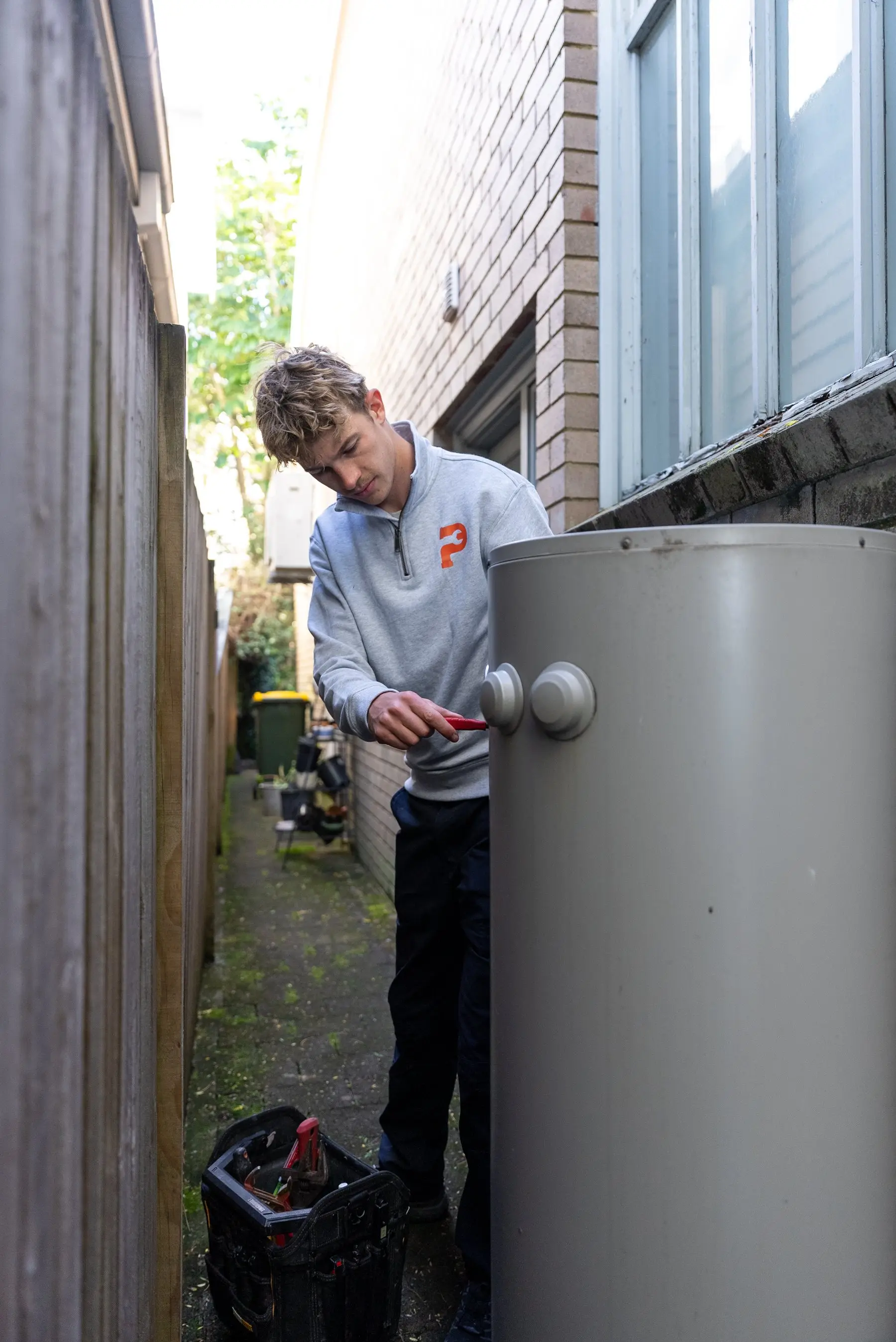 A Plumbwell plumber servicing a gas hot water system in Sydney