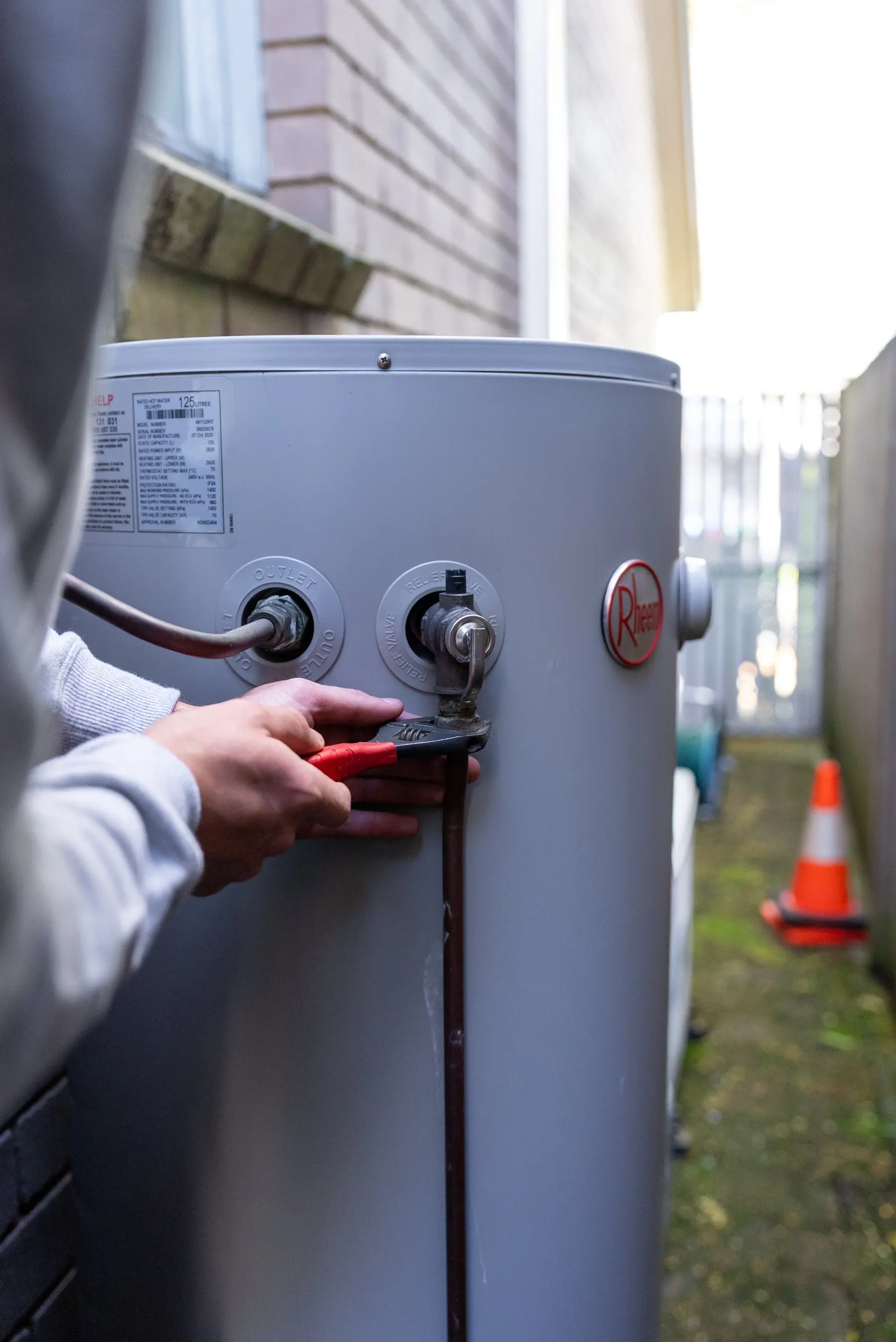 A Plumbwell plumber repairing a hot water system valve