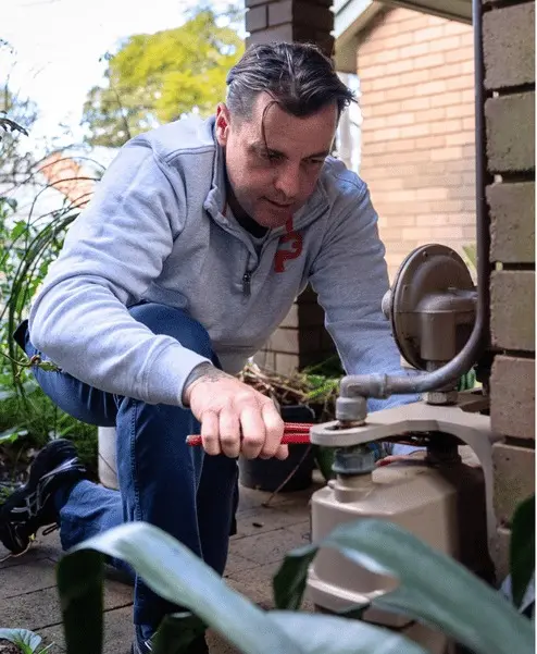 A Plumbwell plumber working on a gas meter