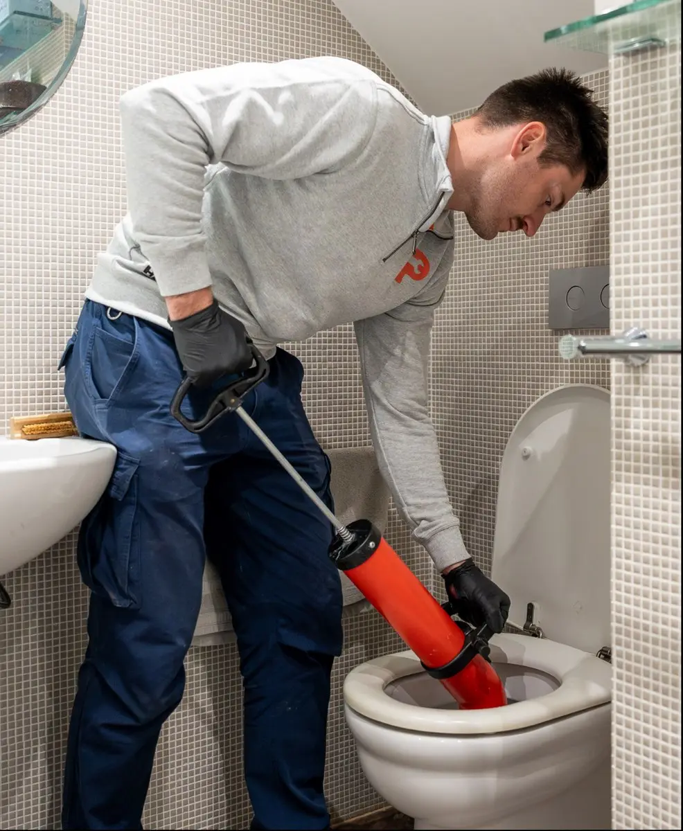 A Plumbwell plumber clearing a blocked toilet